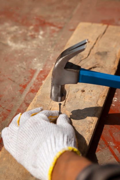 Photo travailleur de la construction à l'aide d'un marteau sur le chantier