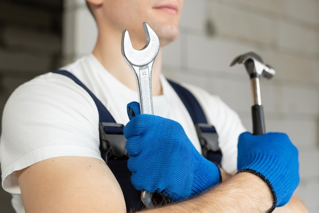 Travailleur de la construction masculin portant un casque avec un marteau et une clé