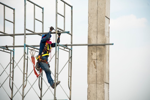 Travailleur de la construction travaillant sur des échafaudages dans le chantier de construction