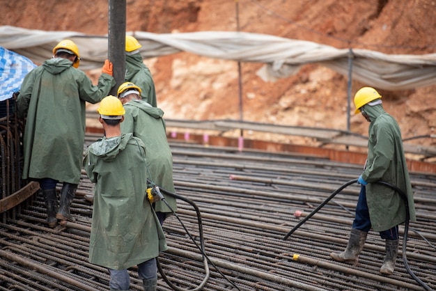 Travailleur de la construction versant un béton à la fondation de masse