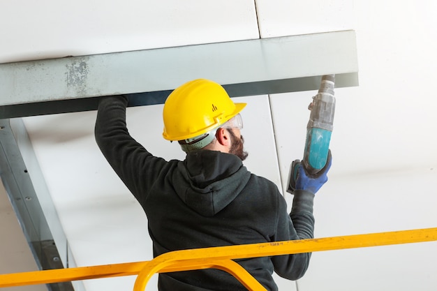 Travailleur construit un mur de plaques de plâtre.