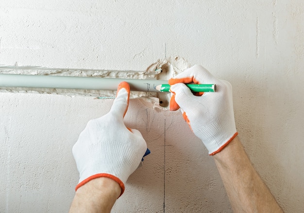 Travailleur coupant la partie de l'isolation avec un cutter