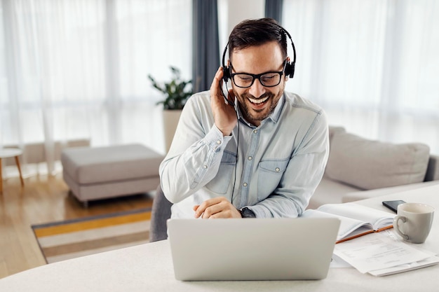 Un travailleur à distance assis à la maison et ayant une conférence téléphonique avec l'équipe