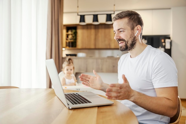 Un travailleur à distance heureux rencontre des employeurs en ligne tout en prenant soin de sa fille