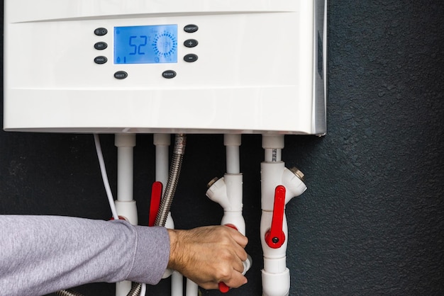 Photo travailleur à distance ou installation d'une chaudière à gaz à double circuit pour le chauffage domestique en hiver et le chauffage de l'eau économie d'énergie