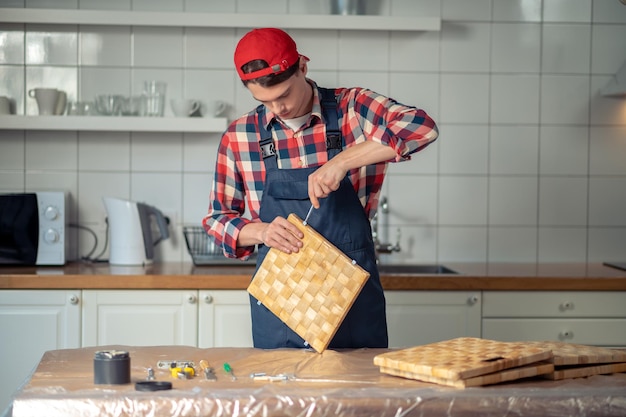 Travailleur du bois concentré sérieux faisant une boîte de paille