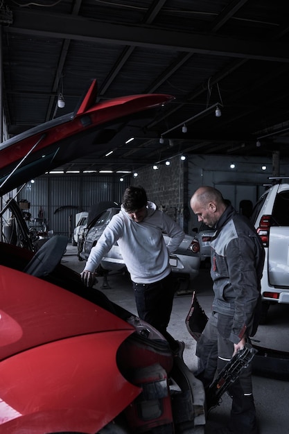 Le travailleur de l'entretien automobile répare la voiture