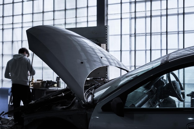 Photo le travailleur de l'entretien automobile répare la voiture