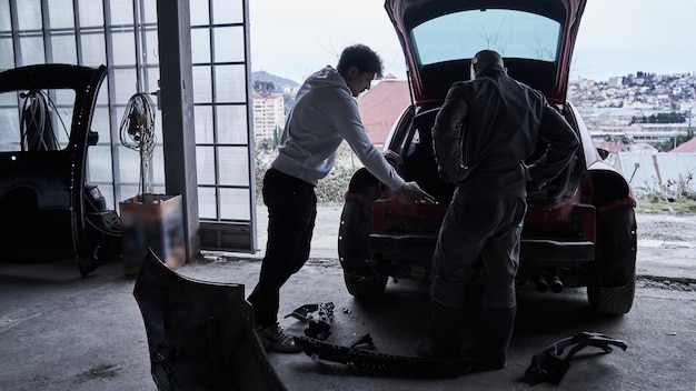 Le travailleur de l'entretien automobile répare la voiture