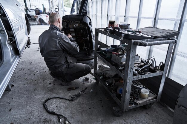 Le travailleur de l'entretien automobile répare la voiture