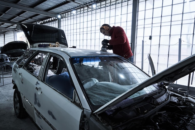 Photo le travailleur de l'entretien automobile répare la voiture