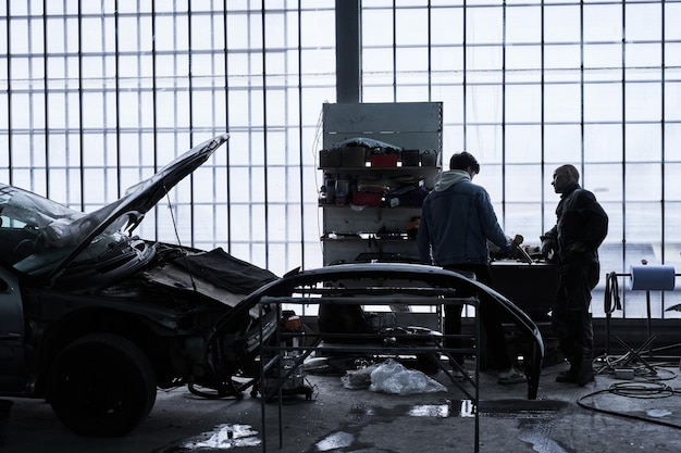 Photo le travailleur de l'entretien automobile répare la voiture