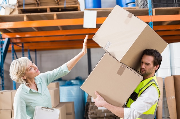 Travailleur équilibrant des cartons lourds