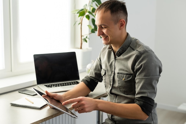 Un travailleur excité assis au bureau dans un espace de coworking utilise un message de lecture d'ordinateur en regardant l'écran de l'appareil a reçu une grande opportunité ou une récompense incroyable. Employé motivé célébrant la promotion de l'emploi.