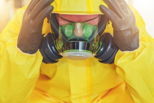 Photo travailleur d'hôpital frustré dans un masque à gaz biochimique et une combinaison de protection chimique