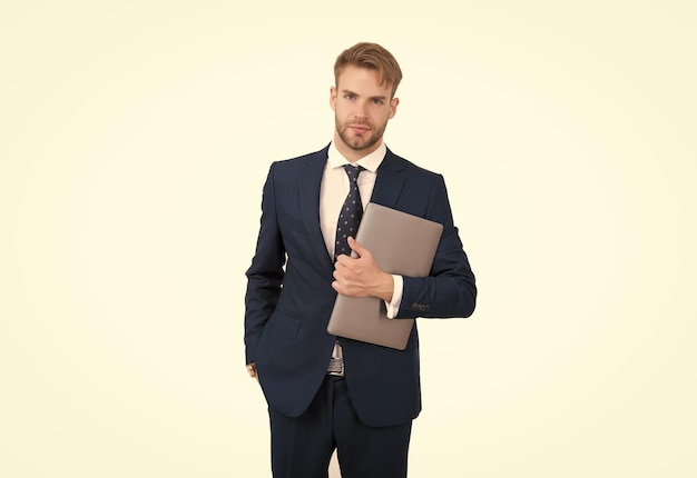 Un travailleur indépendant en costume formel tient un ordinateur portable pour travailler en freelance en ligne
