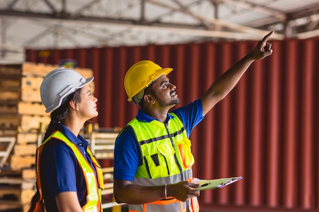 Travailleur indien travaillant avec une équipe féminine travaillant dans la formation de l'industrie de la logistique du fret aidant ensemble un sourire heureux