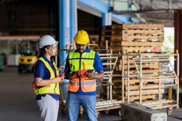 Travailleur ingénieur indien hispanique travaillant dans le port d'expédition de fret ensemble femme travaille avec un homme dans l'industrie de l'entrepôt