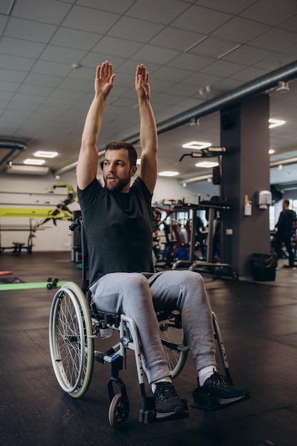 Travailleur invalide faisant de l'exercice avec des poids dans la salle de sport