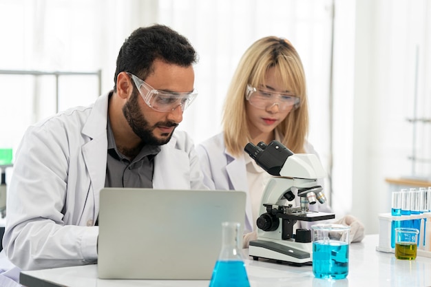 Travailleur de laboratoire à l'aide d'une loupe sur un microscope