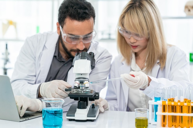 Travailleur de laboratoire à l'aide d'une loupe sur un microscope