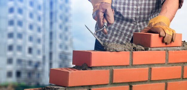 Travailleur maçon installant la maçonnerie de brique