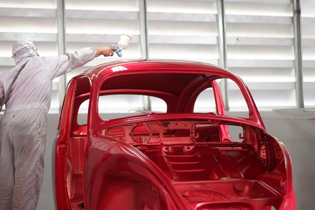 Photo travailleur manuel peignant une voiture dans un atelier