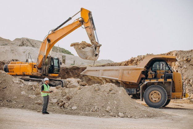 Travailleur masculin avec bulldozer dans la carrière de sable