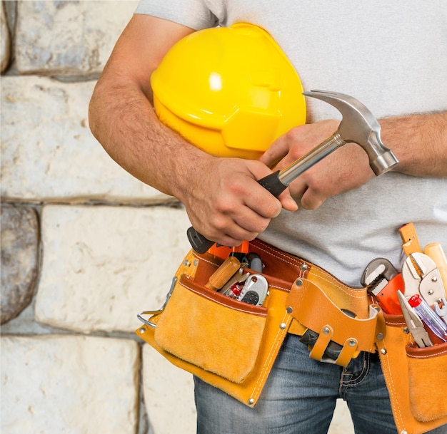 Travailleur masculin avec ceinture à outils isolé sur fond