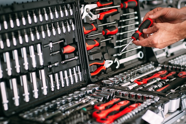 Travailleur masculin choisissant un tournevis dans le magasin d'outils