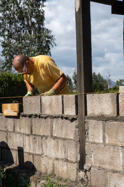 Un Travailleur Masculin Construisant Un Mur Avec Des Parpaings