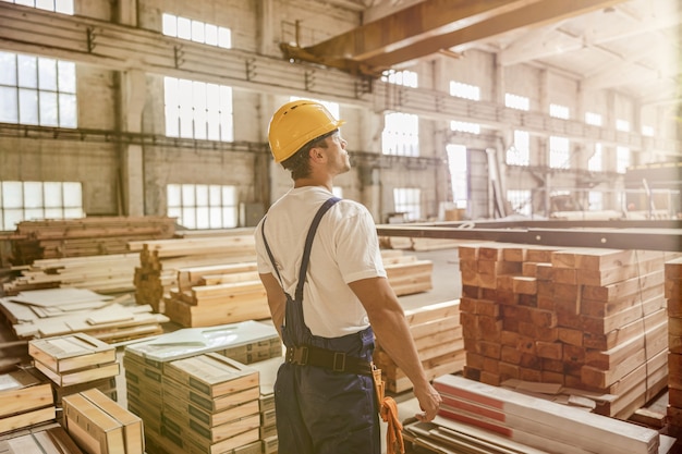 Travailleur masculin debout par des matériaux de construction dans le bâtiment