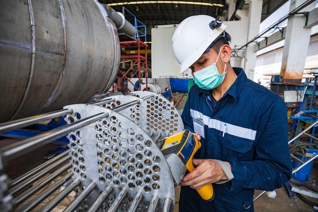 Travailleur masculin inspectant la surface sur l'entrepôt de construction industrielle de faisceau de tubes d'échangeur de chaleur positif