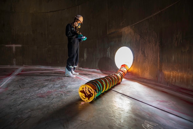 Travailleur masculin inspection visuelle produits chimiques ventilateur en acier inoxydable air frais dans le réservoir de stockage espace confiné