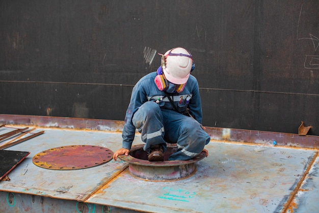 Le travailleur masculin à l'intérieur du réservoir d'inspection visuelle de stockage de réservoir de ponton dans l'espace confiné est l'air de ventilateur