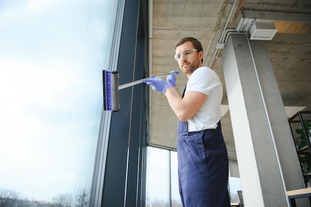 Photo travailleur masculin laver le verre de la fenêtre