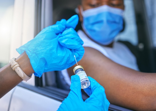 Travailleur médical Covid et site de vaccination et service pour le patient qui se fait vacciner contre la grippe ou dose pour la prévention du coronavirus Homme en voiture avec masque facial pour éviter tout contact lors de l'injection