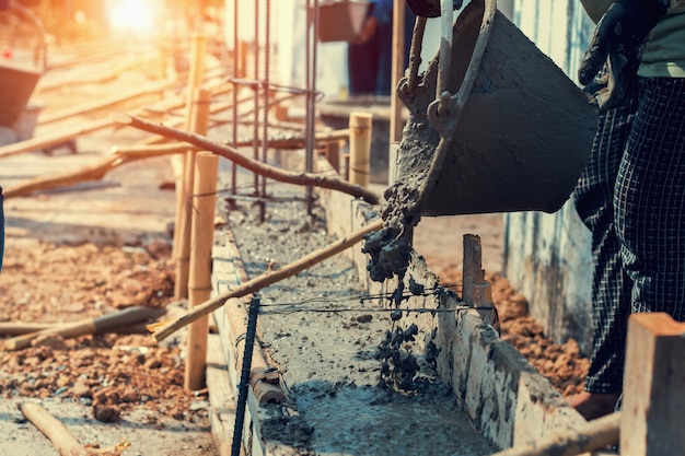 Travailleur mélangeant pour ciment de construction sur le sol pour la maison de construction