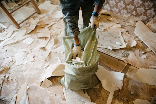 Travailleur nettoie les poubelles dans l'appartement dans le sac