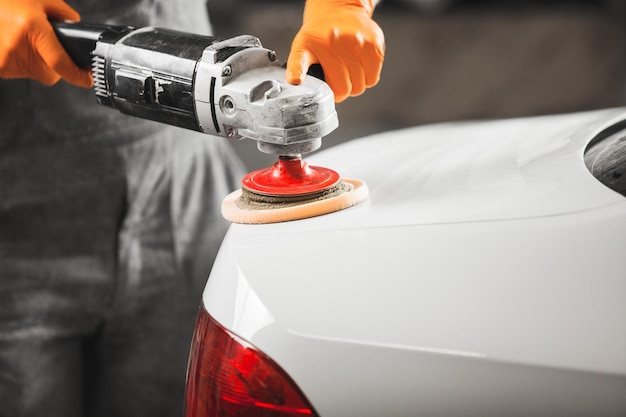 Travailleur nettoyant une voiture blanche avec un gros plan de polissage et de cirage Atelier de réparation automobile