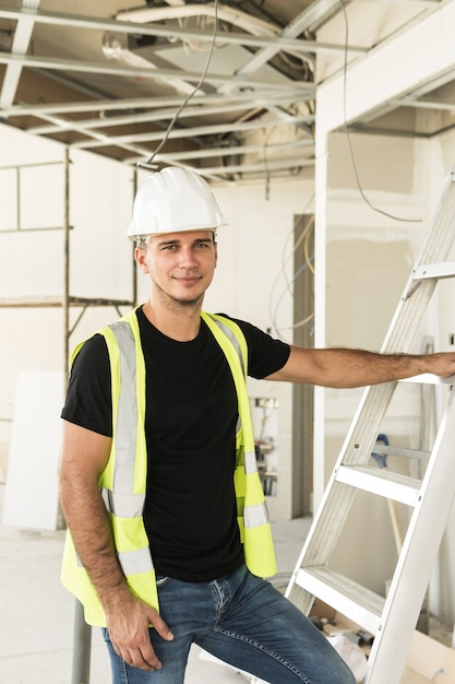 Photo travailleur portant un casque nad gilet de sécurité sur un chantier de construction