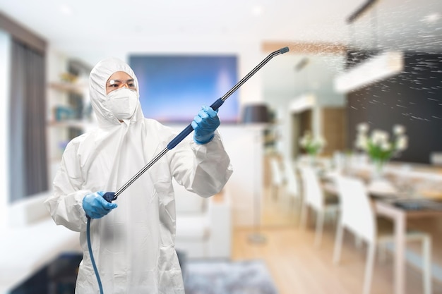 Le travailleur porte une combinaison de protection médicale ou une combinaison désinfectée avec un spray