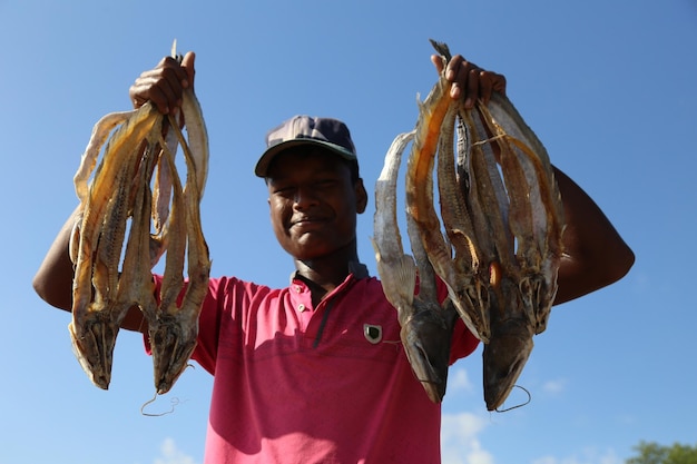 Un travailleur pose avec un poisson à la main pendant le processus d'exportation.