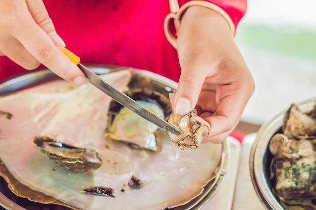 Le travailleur prend la perle de la coquille