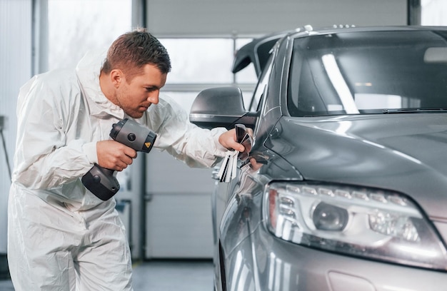 Travailleur professionnel L'homme en uniforme est au service automobile