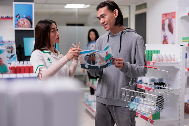 Travailleur de la santé donnant des conseils à un jeune homme en pharmacie, aidant avec des médicaments pharmaceutiques. Pharmacien et client examinant des bouteilles d'édication ou des boîtes de prescription.