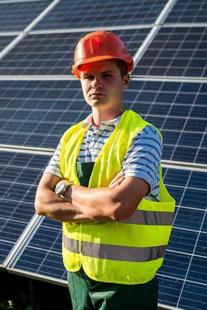 Le travailleur se tient avec le projet près des panneaux solaires