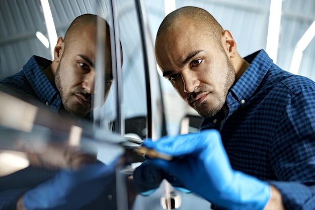 Travailleur de service de voiture afro-américain appliquant un nano-revêtement sur une voiture