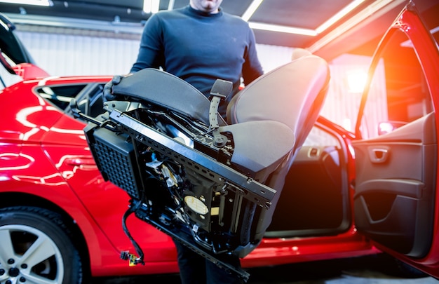 Photo le travailleur de service de voiture démonte l'intérieur de la voiture