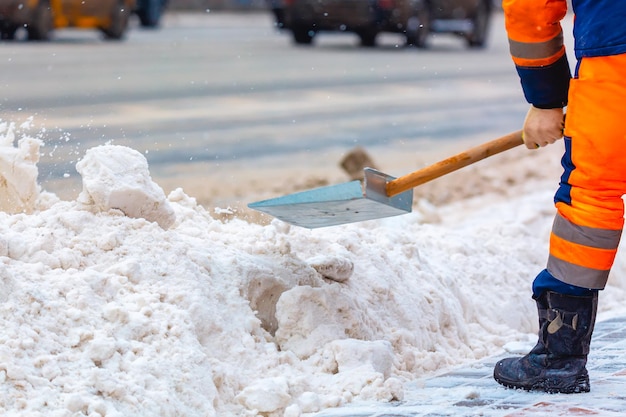 Le travailleur des services communaux balaie la neige de la route en hiver, nettoie les rues et les routes de la ville pendant la tempête de neige. Moscou, Russie.